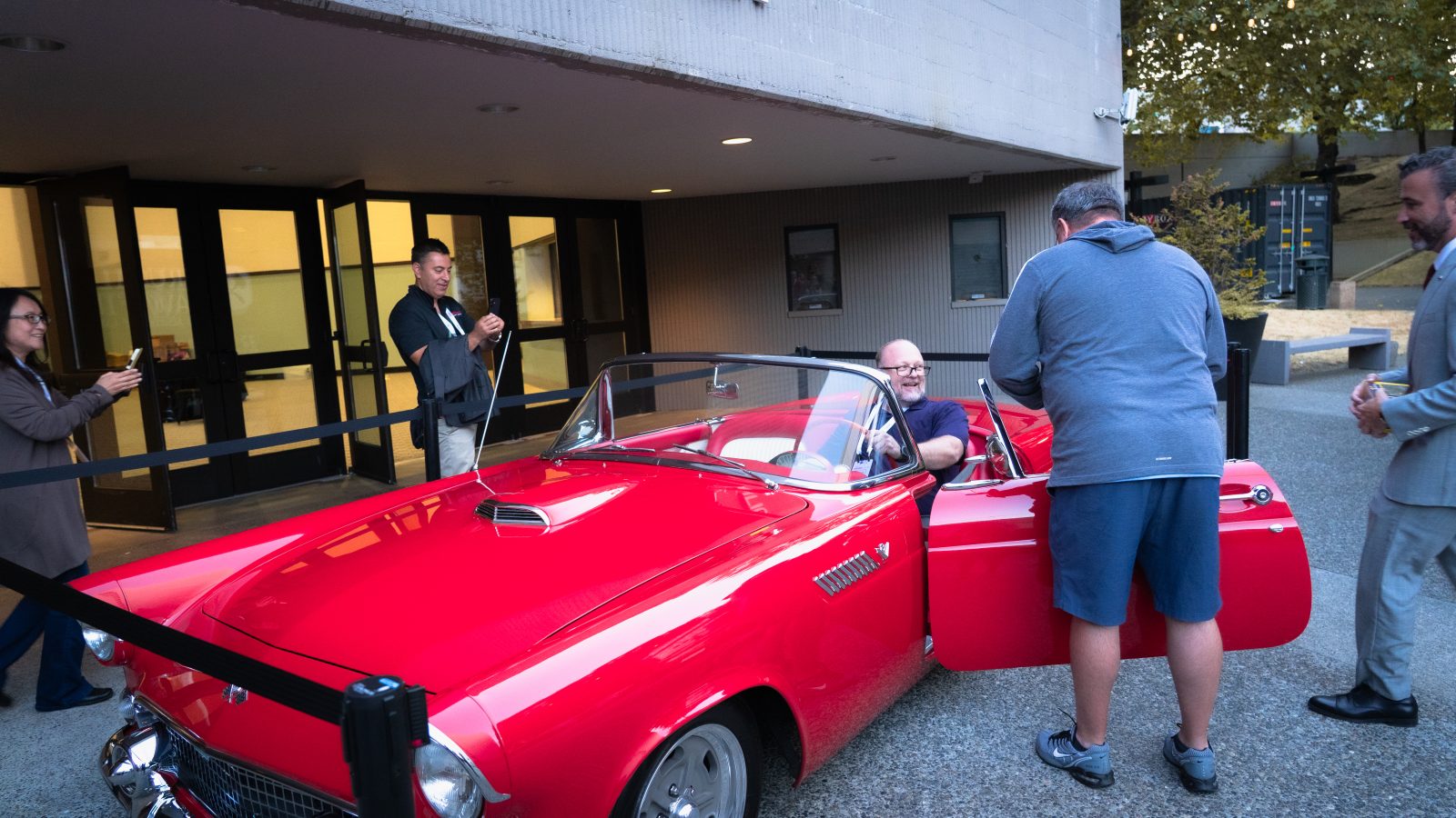 Attendees photograph the winner sitting in the Thunderbird.