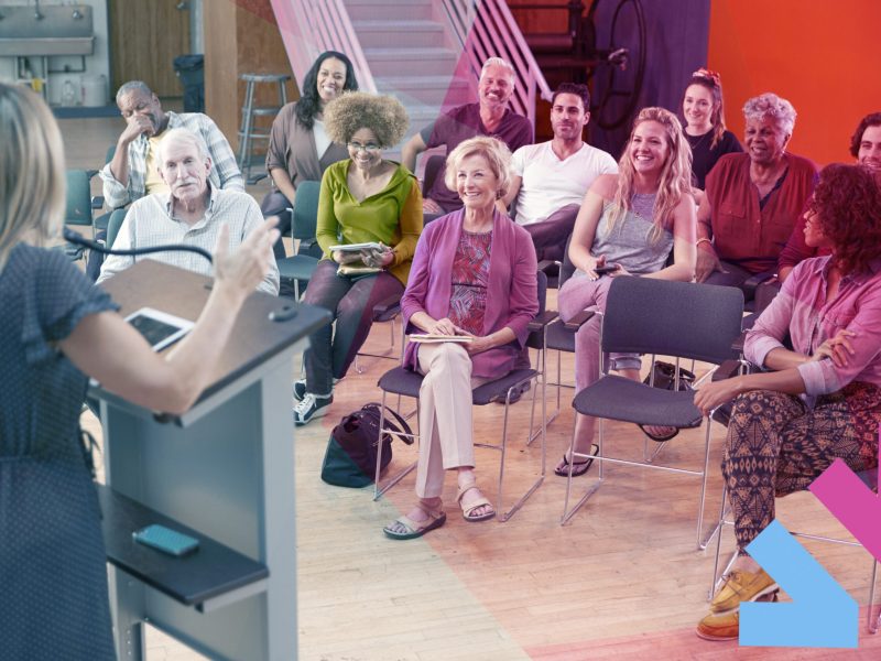 Group Attending Neighborhood Meeting Listening To Speaker In Community Center